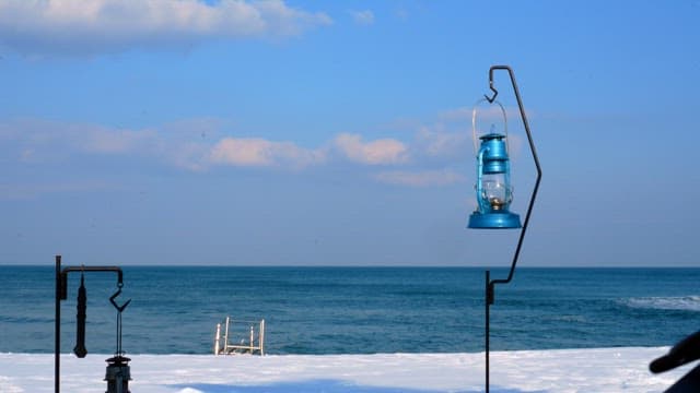 Camping lanterns installed on a snowy beach by the sea