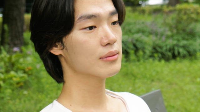 Young man relaxing on a park bench