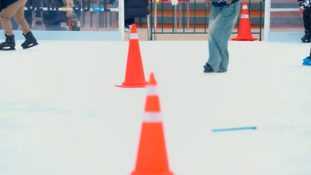 People ice skating around cones