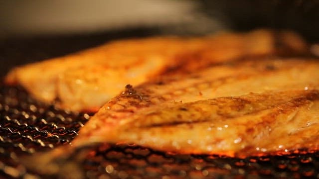 Grilled fish sizzling on a hot grill