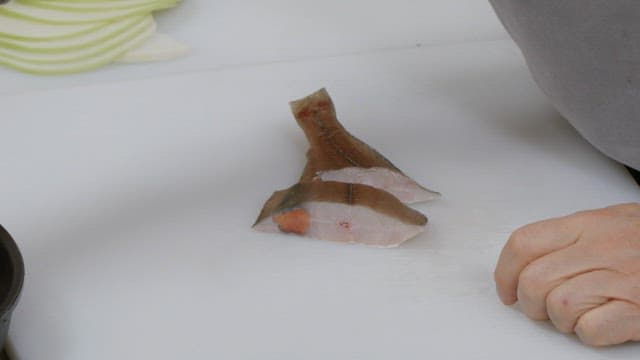 Putting prepared fish into a pot for cooking