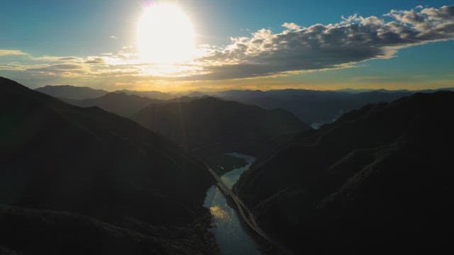Aerial View of Sun Setting Behind Mountains