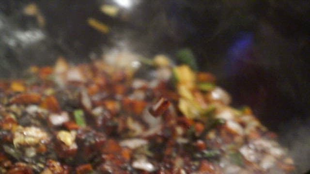 Stir-frying meat and vegetables in a wok with black bean paste