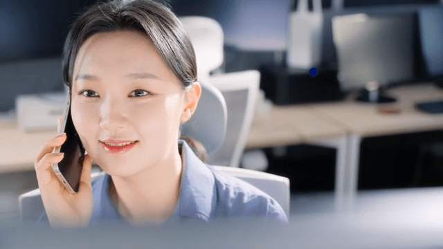 Woman talking on the phone at office desk