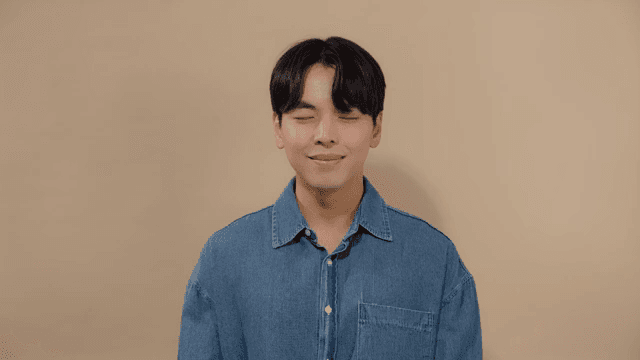 Man meditating with his eyes closed and a satisfied smile on his face