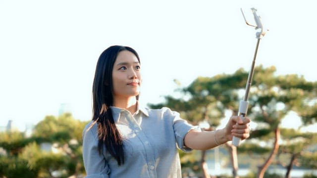 Woman taking a selfie in a park