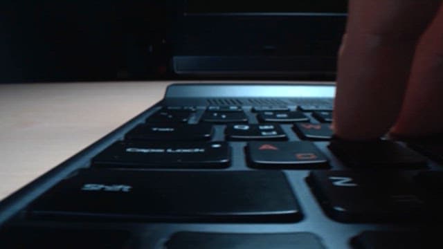 Fingers Tapping on Laptop Keyboard in Office