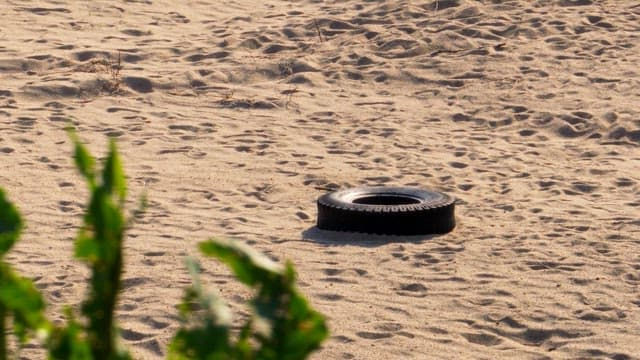 Tire abandoned on a sandy ground under the sun