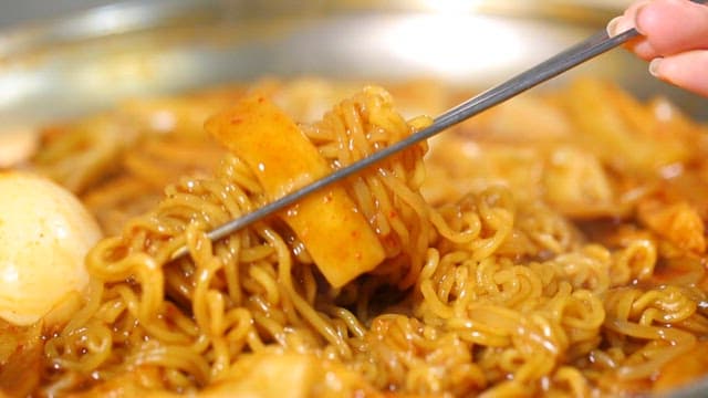 Chopstickful of spicy tteokbokki with ramen