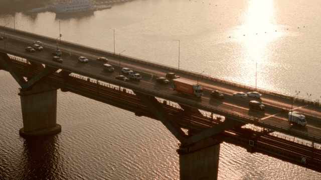 Vehicles crossing a bridge at sunset
