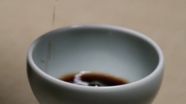 Pouring soy sauce into a cup