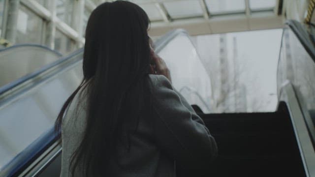 Woman in a mask talking on the phone outdoors