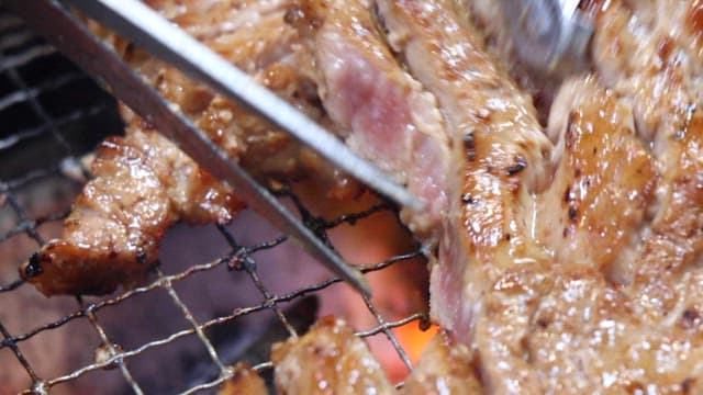 Marinated Beef Slices Being Cooked on a Grill