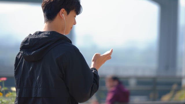 Man walking in a park with earphones