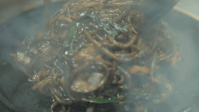 Seafood Jjajang noodles being cooked on a hot plate