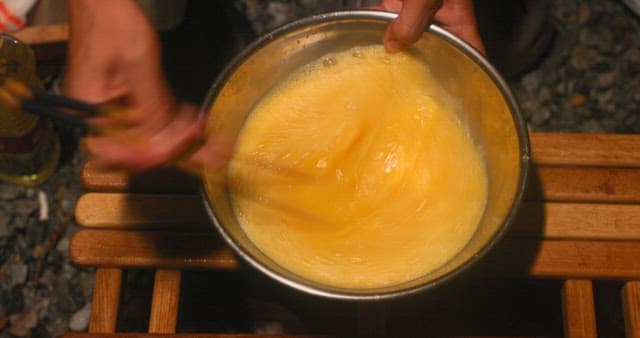 Cooking eggs in a bowl at a camping site